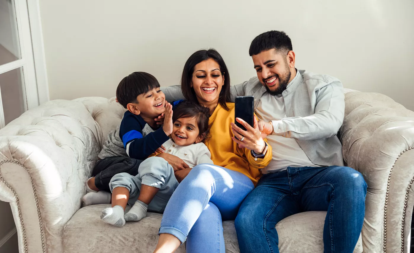  Family sitting on couch, wife in mustard sweater
