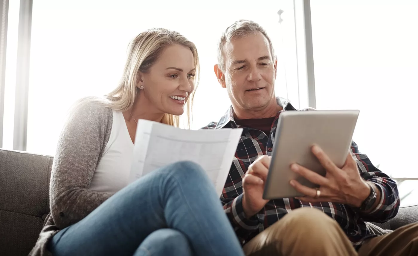  A couple sits on their couch and reviews probate information on a tablet.
