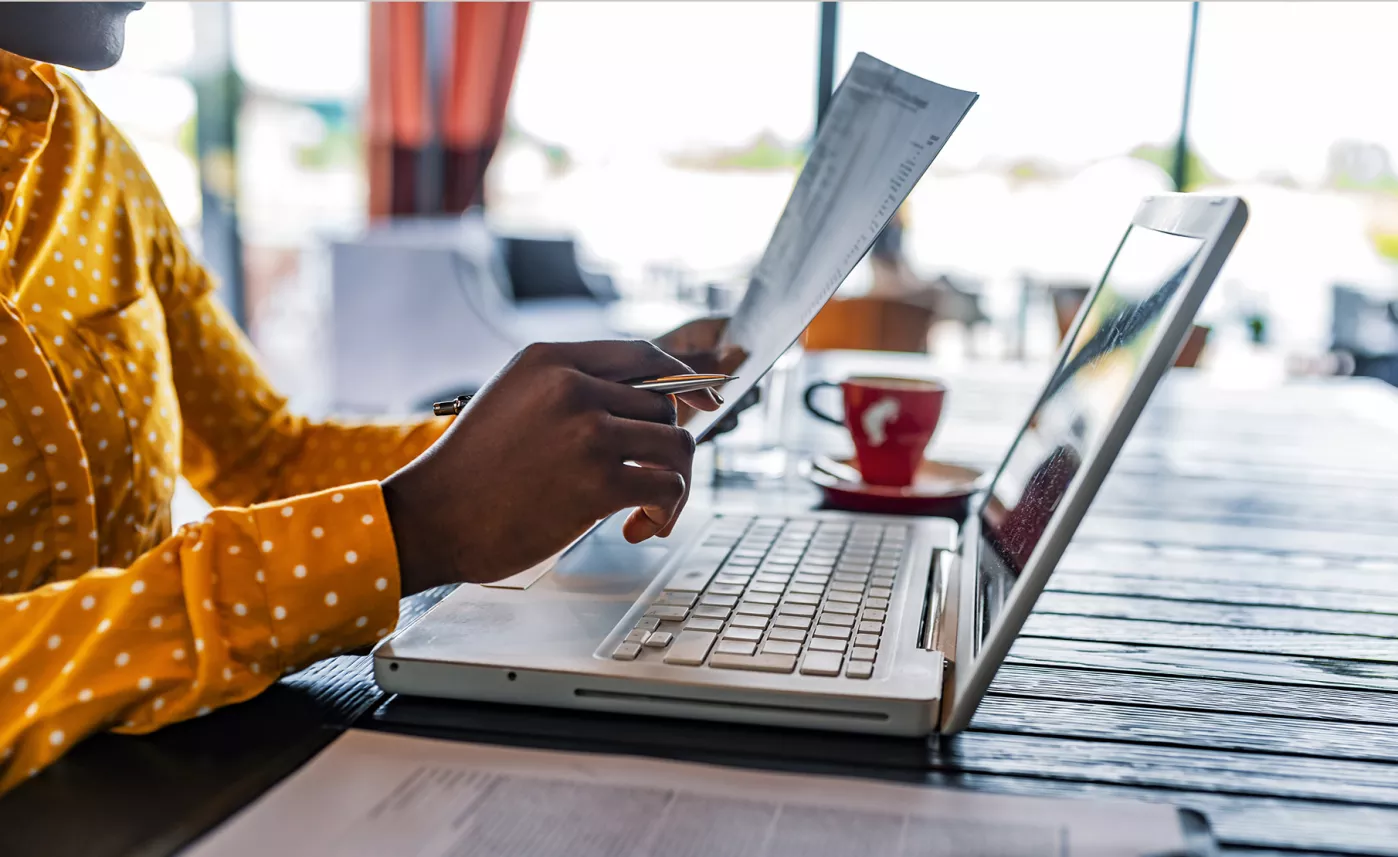  A woman reviews her tax forms at a cafe.
