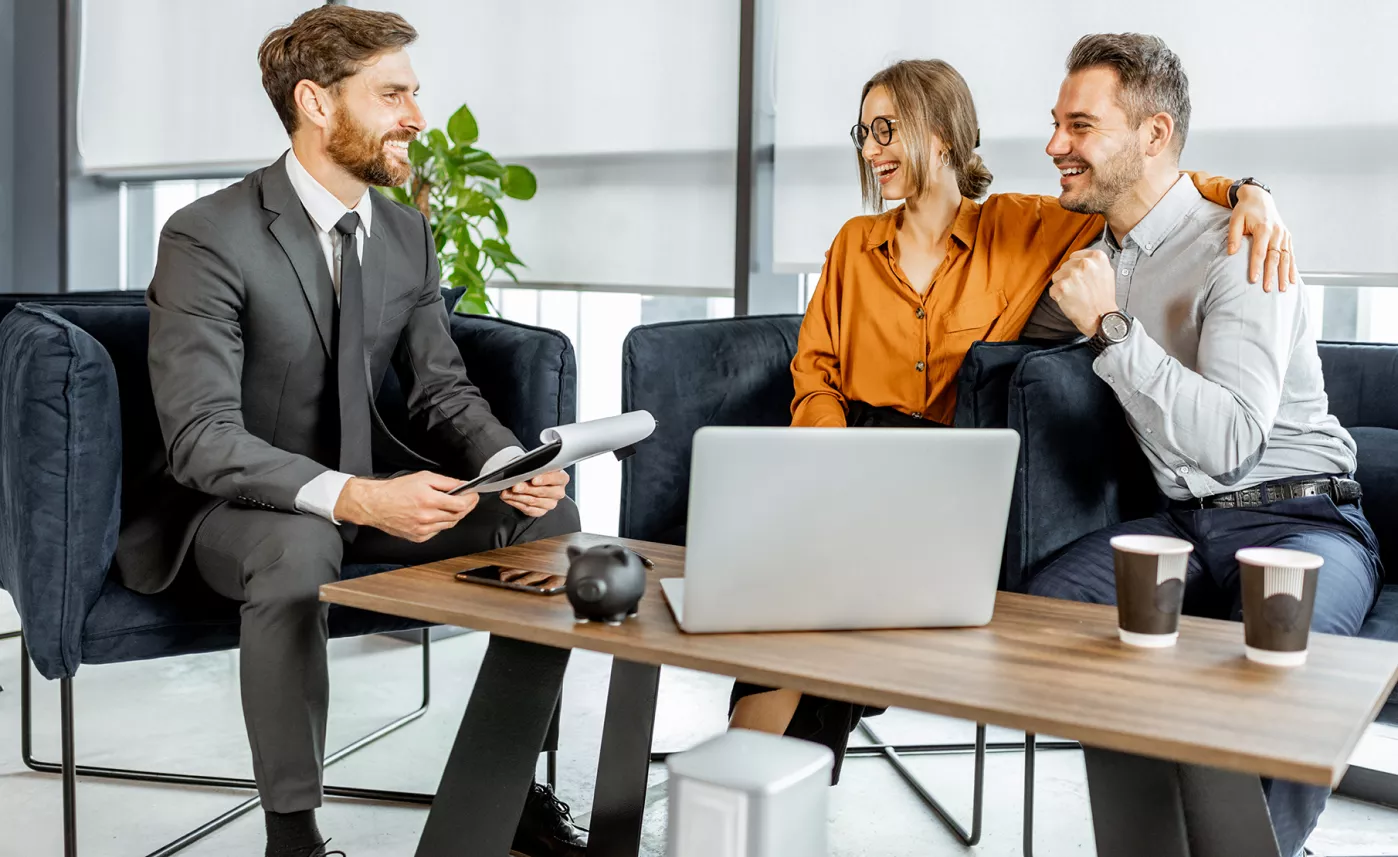  An Edward Jones financial advisor helps two clients balance their portfolio in his branch office.
