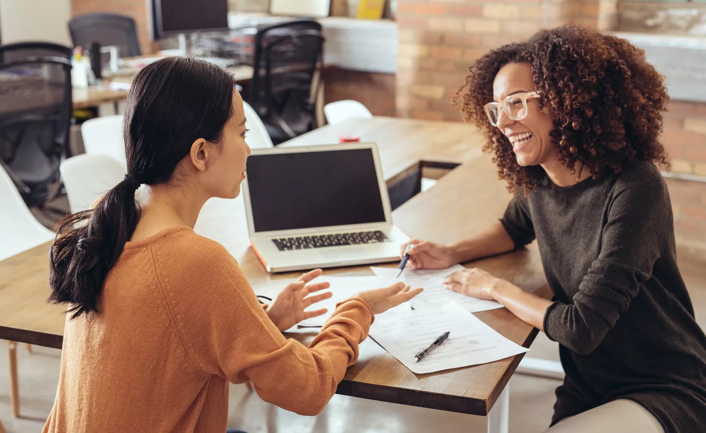  An Edward Jones financial advisor talks through some documents with her client as they sit in her office.
