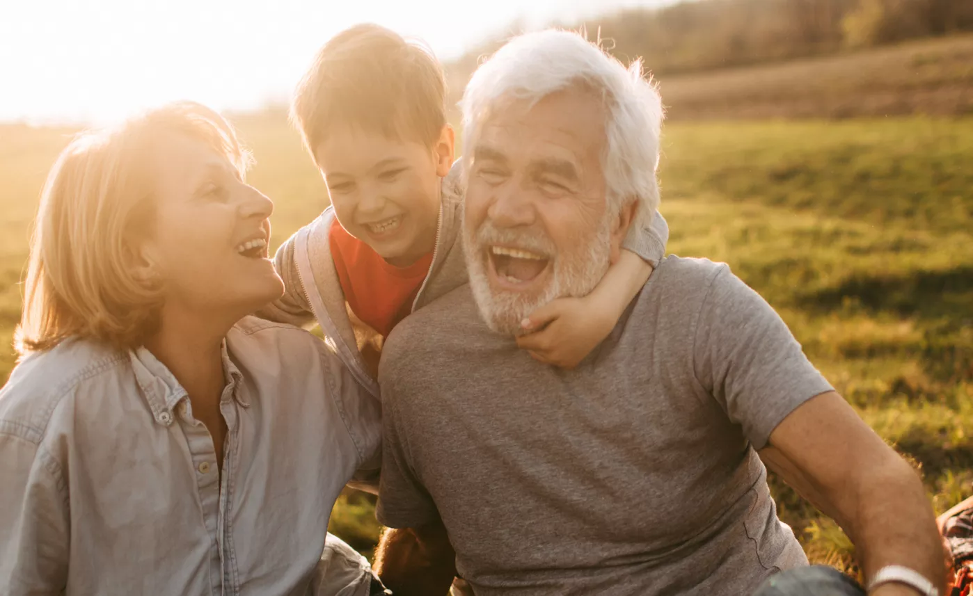  A grandson hugs his grandparents as they laugh together.
