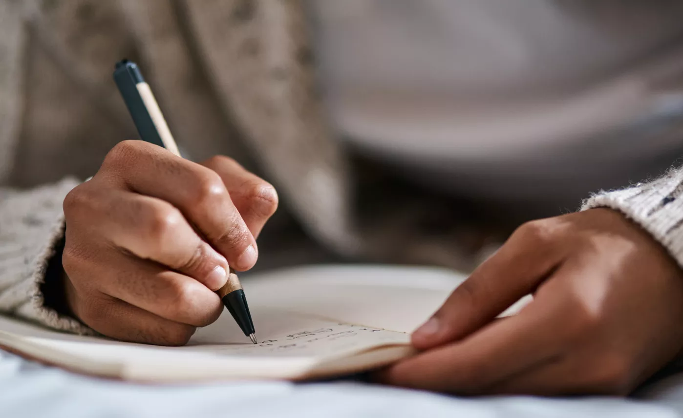  A person writing in their notebook.

