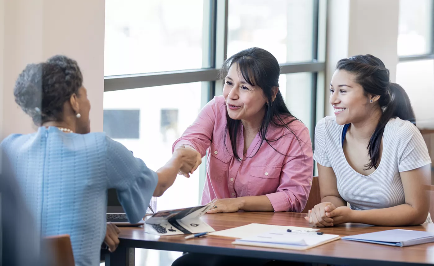  Women shaking hands across a table
