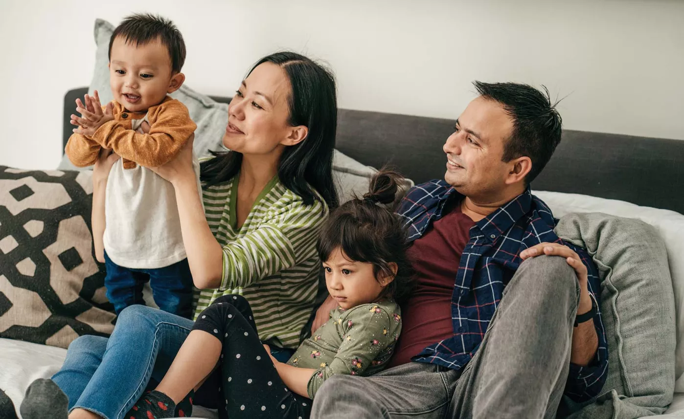  Family sitting in a couch and playing with children
