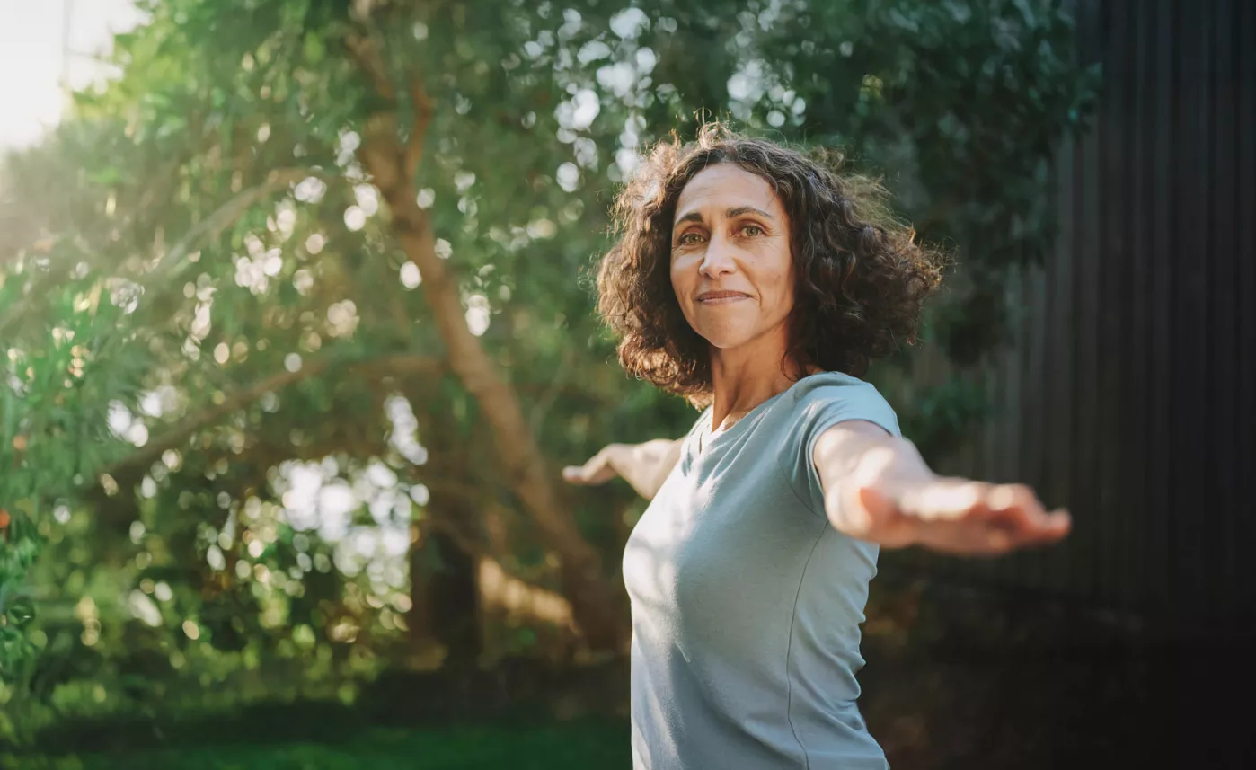  A middle aged woman finding peace while doing yoga in the park.
