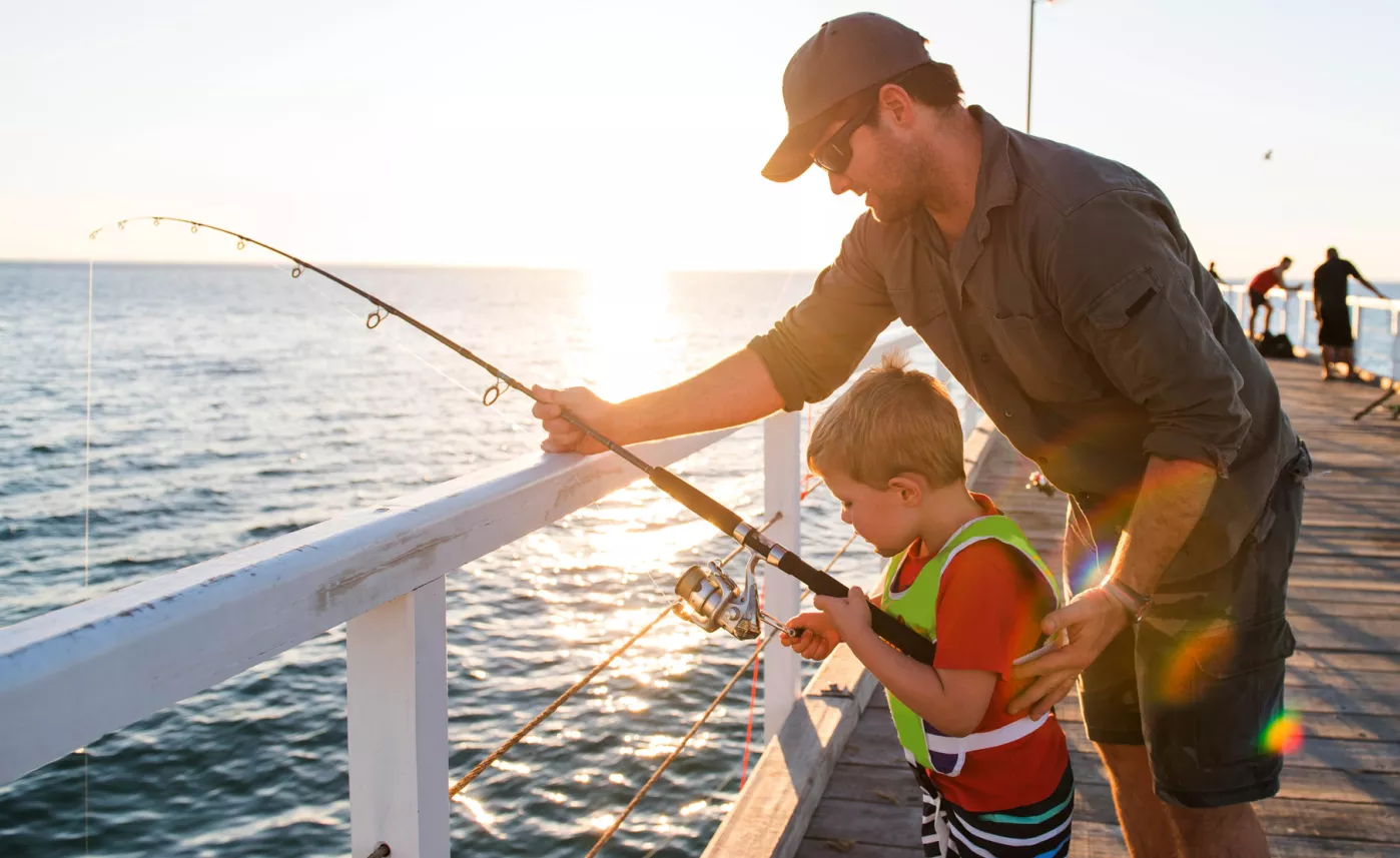  A man and his young son fishing off a pier.

