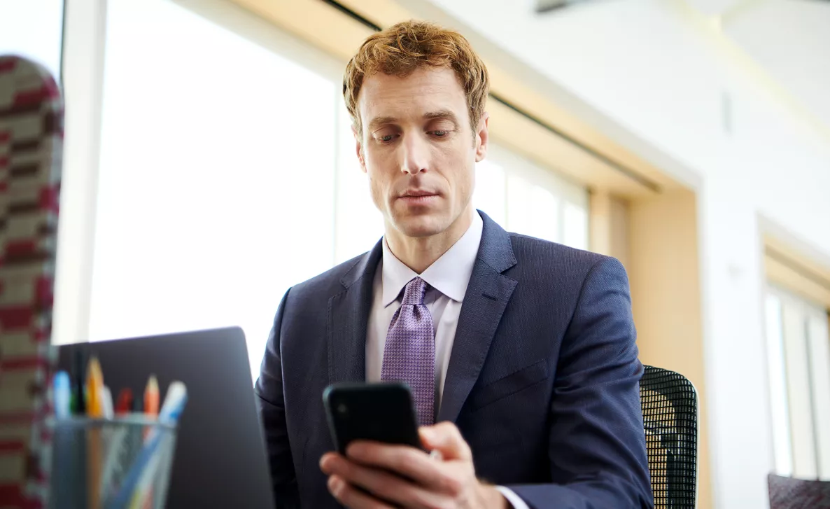  An Edward Jones client is transferring funds on his mobile phone.
