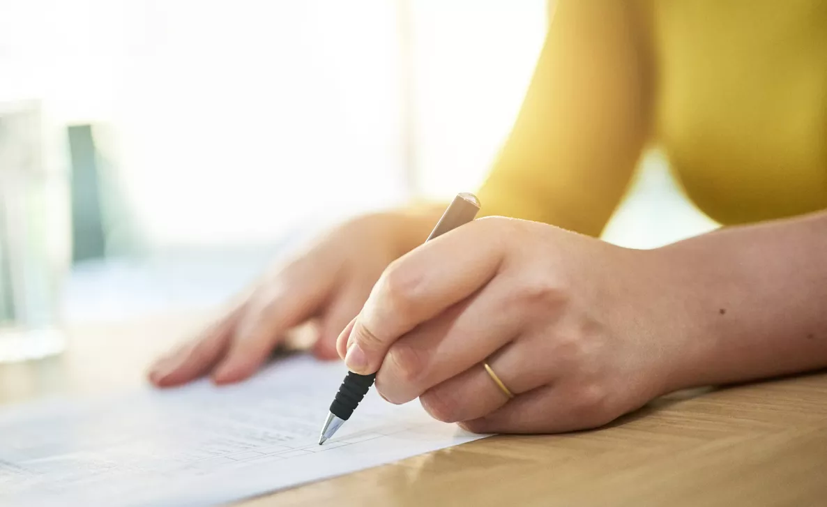  A woman checks off tasks from a list on a sheet of paper.
