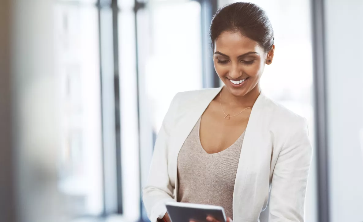  A woman smiles as she checks her Edward Jones account on her tablet.
