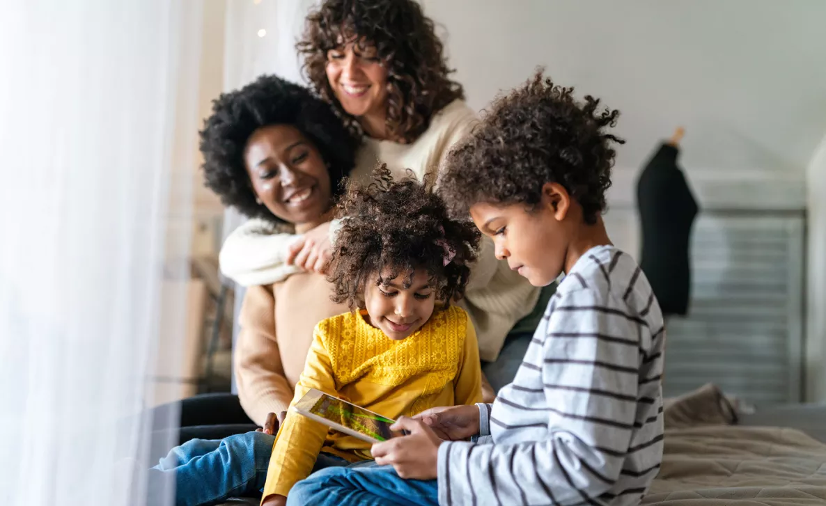  Une famille est assise pendant qu’un enfant joue sur une tablette.
