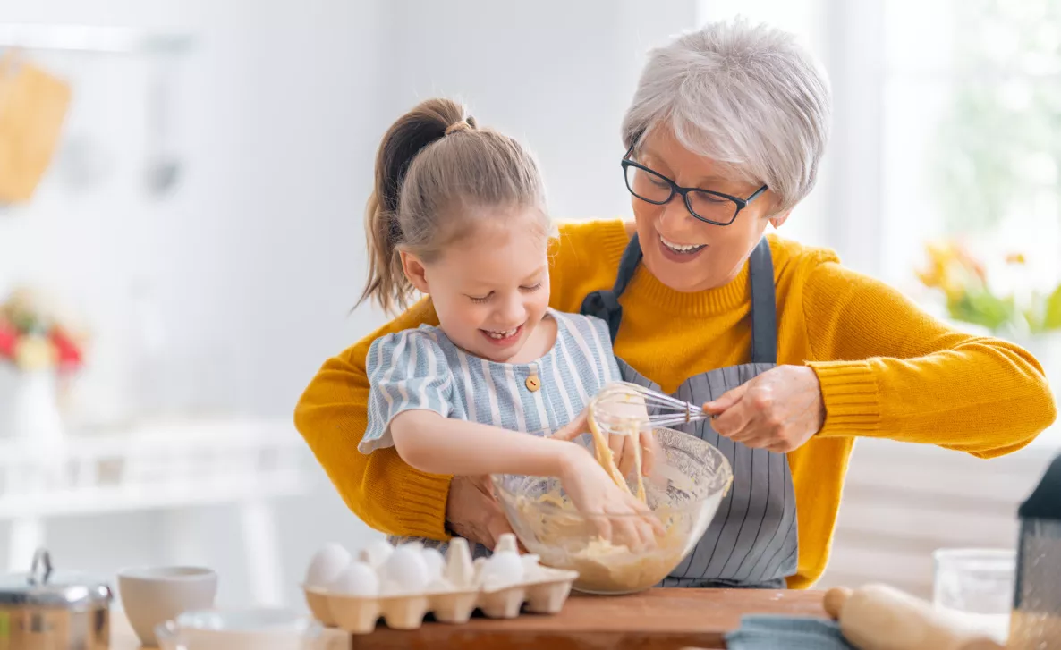  Grandma stirring the egg mix along with her grand daughter
