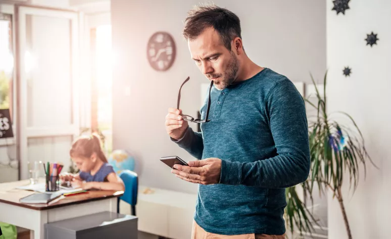 Father looking at mobile device