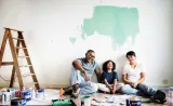Couple and child sitting on the floor painting