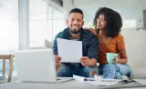 A young couple reviews a tax guide as they prepare to file.