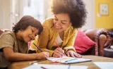 Siblings writing on paper