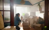 30 year mortgage: A young boy helps is mother unpack moving boxes.