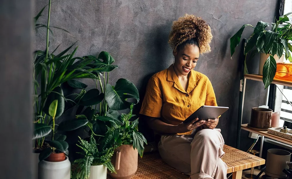 A woman smiling and looking at tablet